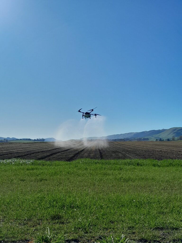 Agricultural spray drone applying a pass over a cultivated paddock
